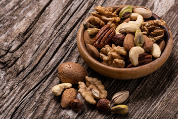 variety of dried fruits in the bowl and on the old wooden table in extreme close-up.