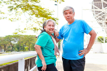 Obraz premium Asian elderly couple smiling happily after exercising outdoors together. Sports concept. health care in retirement