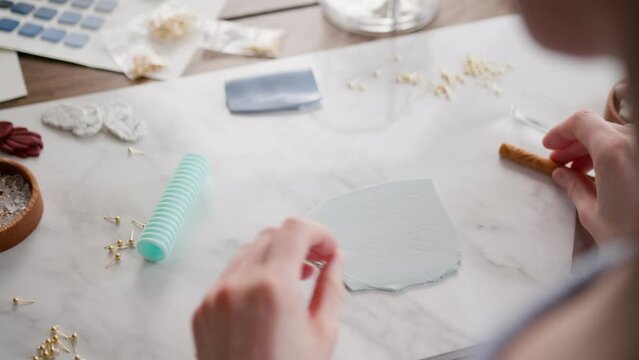 close up view of making handmade earrings of polymer clay  using gold accessories and tools. 
