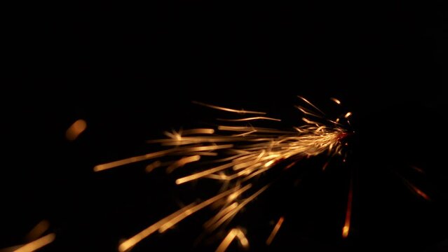 Fiery splashes of Bengal fire with stars glitter brightly on a black background. An essential attribute of a Merry Christmas. Slow motion with glare.