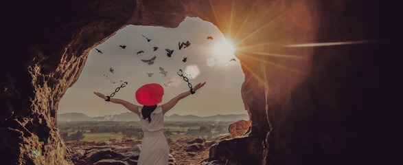 The woman is breaking the chains and setting the birds free, in a cave at the top of a mountain...