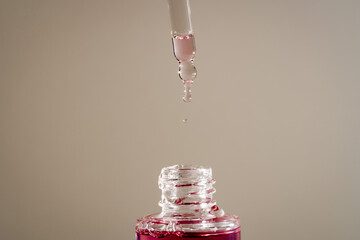 Pink face oil with glass pipette