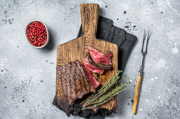 BBQ Grilled Wild Venison steak on wooden board. Gray background. Top view