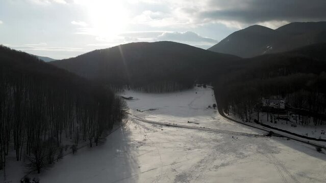 Aerial view of Verteglia Plateau with snow in wintertime at sunset on Mount Terminio, Serino, Avellino, Irpinia, Campania, Italy.