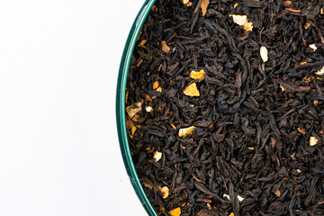 Black tea with orange peel and cinnamon close-up top view