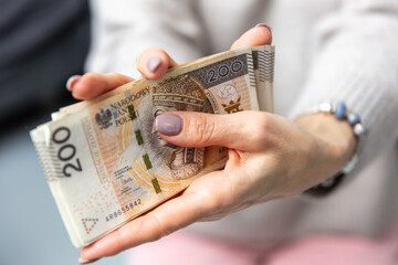Fototapeta Kobieta trzyma w dłoniach banknoty, pieniądze polskie, złotówki. Liczenie pieniędzy. obraz