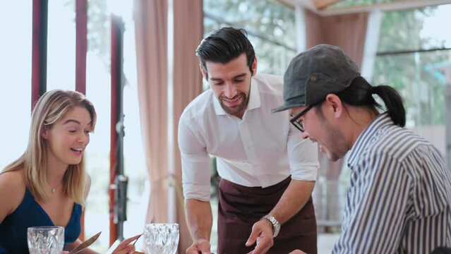Group of friends enjoy eating and talking together with food and sitting at restaurant