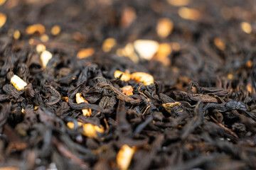 Black tea with orange peel and cinnamon close-up top view