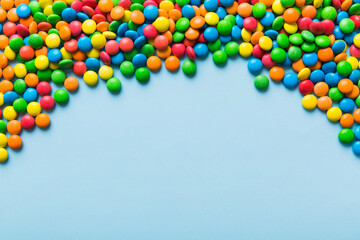 Mixed collection of colorful candy, on colored background. Flat lay, top view. frame of colorful chocolate coated candy