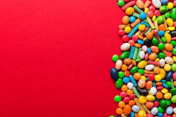 Obraz premium Mixed collection of colorful candy, on colored background. Flat lay, top view. frame of colorful chocolate coated candy