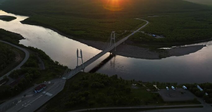Aerial view around the Sami Bridge and Teno river, midnight sun in Utsjoki, Finland - high angle, orbit, drone shot