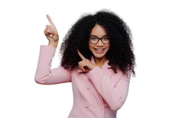 Half length shot of cheerful Afro American woman with dark bushy hairstyle, wears violet suit, points above with both index fingers, demonstrates way to something, invites you going upstairs