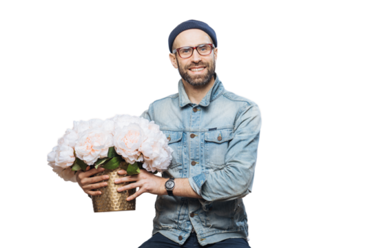 Happy delighted male buys bouquet of flowers for special occasion, wears denim jacket and denim shirt, isolated over white background. Joyful emotional man with present. Beautiful flowers for you