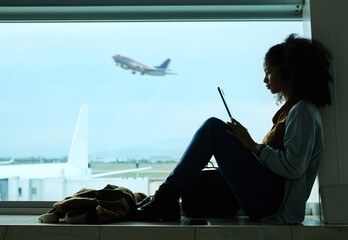 Airport, travel and black woman online with tablet by window waiting for flight, departure and...