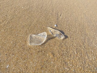 broken glass transparent glass on the beach sand