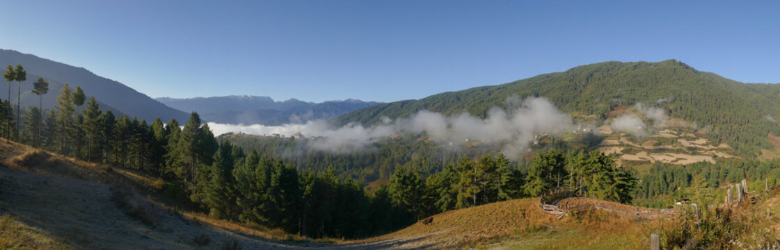 Autumn rural mountain landscape panorama with forest and low clouds, Bumthang valley, Bhutan
