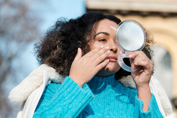 Portrait of chubby young woman applying cream moisturize on face.