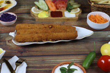 Crispy Fried Chicken Fingers Served Elegantly on Wooden Dining Table with Vegetables and Sauces