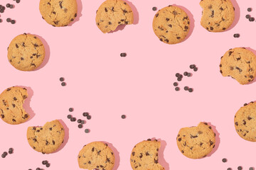 Creative pattern with cookies and chocolate chips on pastel pink background. Retro fashion aesthetic cookie concept. Minimal romantic idea with copy space.