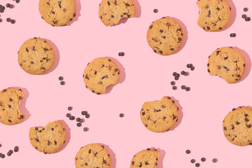 Creative pattern with cookies and chocolate chips on pastel pink background. Retro fashion aesthetic cookie concept. Minimal romantic idea.