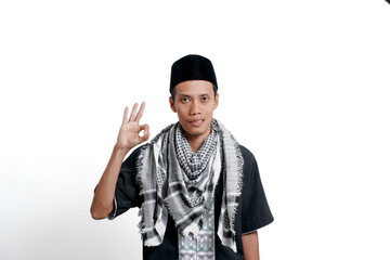 Religious muslim asian man wearing turban, muslim dress and cap. Giving okay or agree sign isolated on white background.