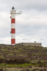 Desert landscape with volcanic rocks, lighthouse and storm clouds. Aabdes, Tenerife, Canary Islands. Spain