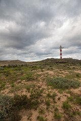 Fototapeta na wymiar Desert landscape with volcanic rocks, lighthouse and storm clouds. Aabdes, Tenerife, Canary Islands. Spain