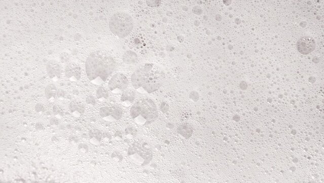 Texture of white soap foam with bubbles abstract background.