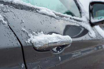 Car door handles covered with snow, ice. The concept of problems with opening the car, freezing car locks.