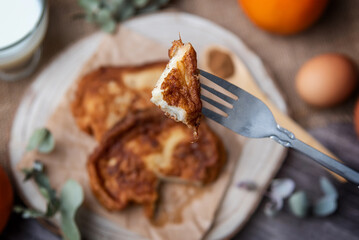 Torrijas. Close-up of a torrija on a fork, a typical Spanish sweet made of bread, milk, eggs, sugar, cinnamon and orange zest that is consumed during Carnival and Easter