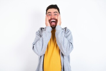 caucasian man wearing casual sportswear over white wall Pleasant looking cheerful, Happy reaction