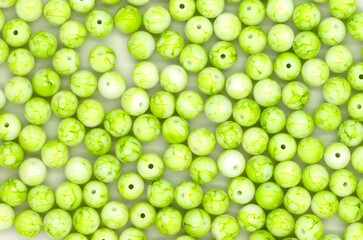 close-up green beads, selective focus with blur effect, background for handicrafts and jewelry, DIY jewelry beads. top view