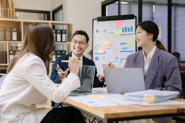 Asian business corporate team brainstorming, planning strategy having a discussion Analysis investment researching with chart at office desk documents in office.