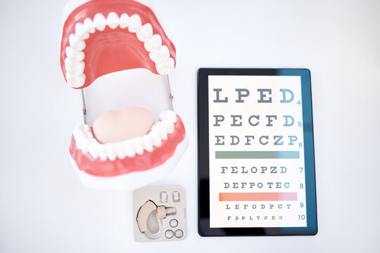 Dental, optometry and otolaryngology equipment to examine, diagnose and test isolated in a studio white background. Mouth, hearing aid and an optotype or eye chart for healthcare, medical or wellness