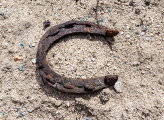 Old rusty horseshoe close-up on the background of sand