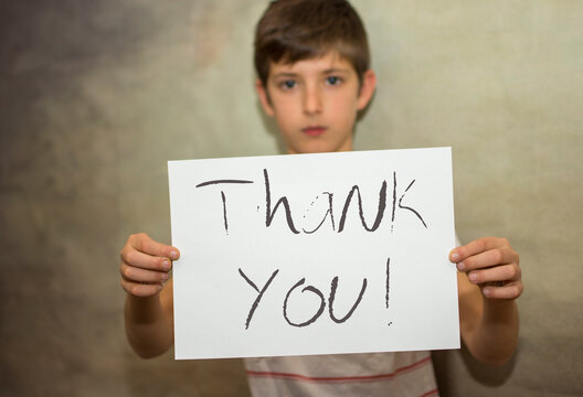 A Child With A Thank You Message Holding A Card