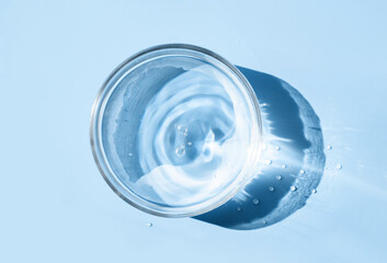 petri dish with liquid water on plain on a light blue background water ripple texture