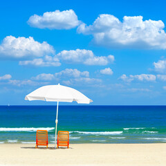 Sandy beach with white sun umbrella and two chairs. Magical comfortable warm and clear season of Mediterranean