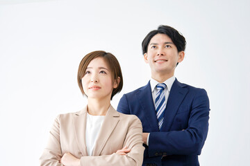 笑顔で腕組みするビジネスウーマンとビジネスマンのポートレート　白背景
