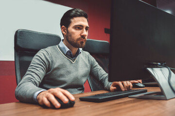 Serious look on businessman's face while he works on computer in the office