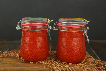 natural red caviar in glass jar closeup photo on kitchen board