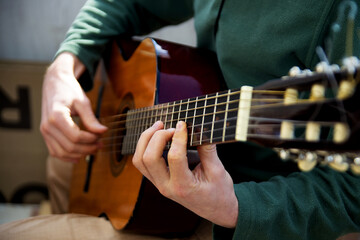 Fototapeta na wymiar Plays the guitar. Guitar strings and fingers. Musical instrument. Man and guitar