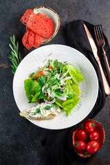 Fresh diet green salad of raw vegetables on a white plate. Vegan Leaf Salad, top view