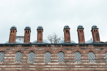 Brick chimney over the brick wall. © Sergey Lorgus