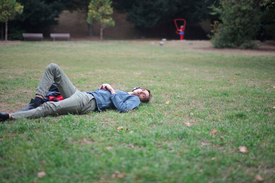 young man lying on a grass in a park
