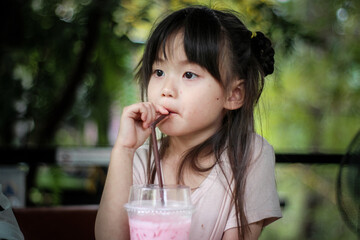 Girl drinking water by giving a straw.