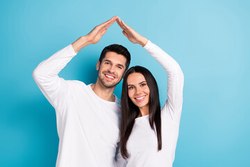 Photo portrait of cute young man woman arms showing house roof mortgage rent wear trendy white garment isolated on blue color background