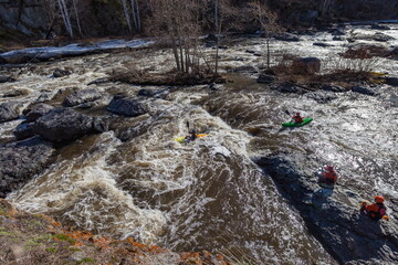 Water sports competitions on kayaks on a full-flowing river in spring