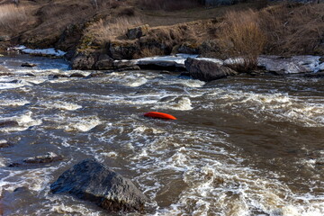 Water sports competitions on kayaks on a full-flowing river in spring