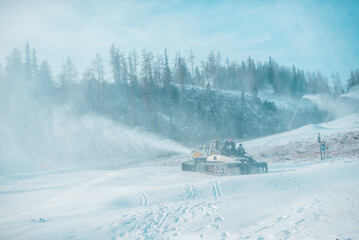 Snow-groomer machine on snow hill ready for skiing slope preparations in High Tatras, snow plow.